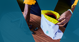 Ruke koje drže VEEV ONE podove i vrećicu za povrat.