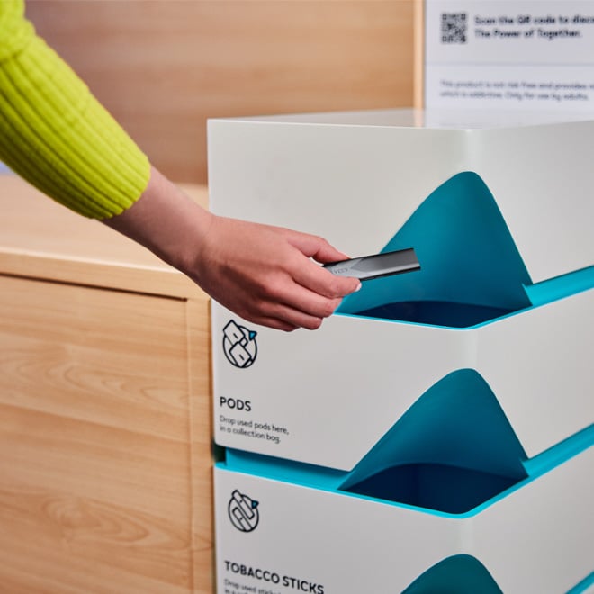 Wrzucanie zużytego urzadzenia do specjlanego pojemnika w sklepie.